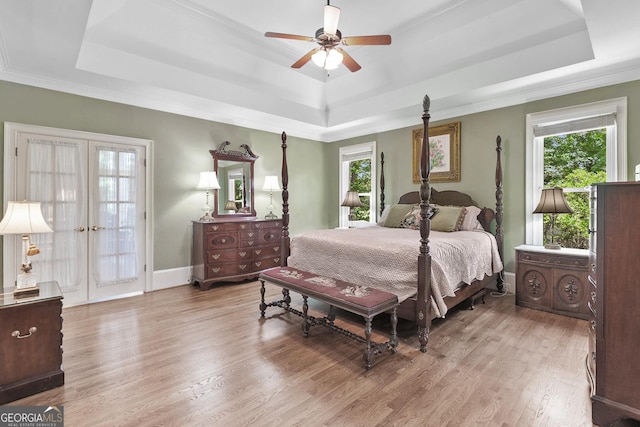 120 Forest Breeze Cv, Alpharetta, GA 30022 - bedroom featuring a tray ceiling, multiple windows, light wood-style flooring, ornamental molding, and french doors