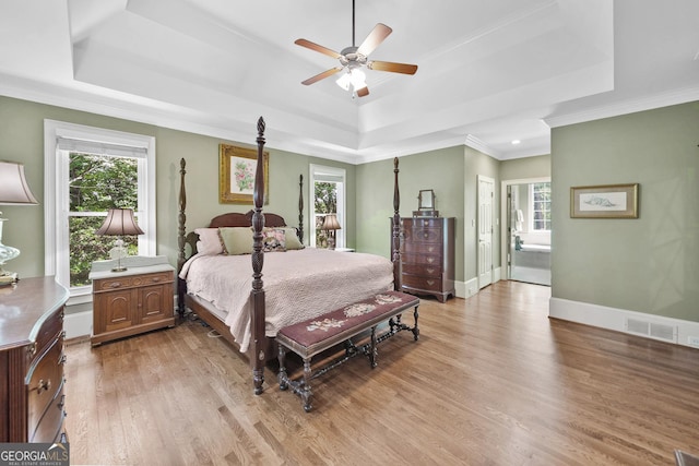 120 Forest Breeze Cv, Alpharetta, GA 30022 - bedroom with a tray ceiling, multiple windows, light wood-type flooring, crown molding, and ensuite bath