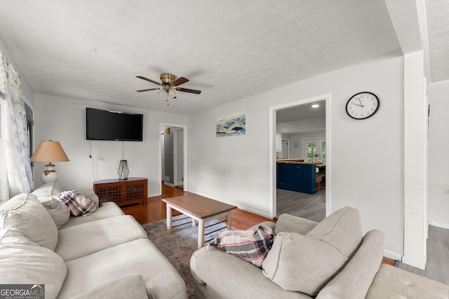157 Glendale Hts, Winterville, GA 30683 - living area featuring wood finished floors, ceiling fan, baseboards, and a textured ceiling