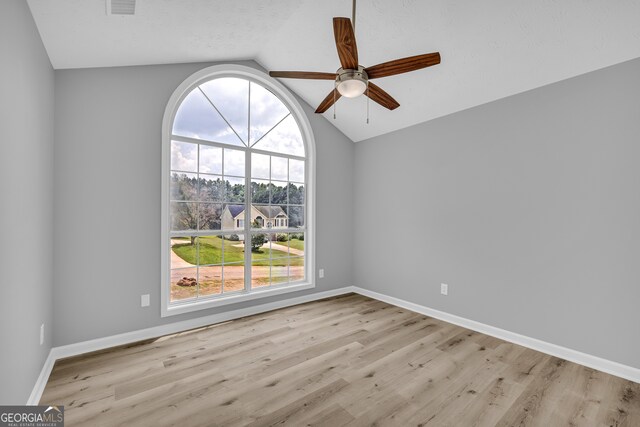 1407 Water Wheel Dr, Bethlehem, GA 30620 - empty room with vaulted ceiling, a ceiling fan, plenty of natural light, wood finished floors, and baseboards