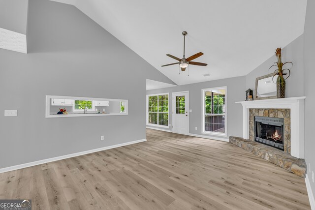 1407 Water Wheel Dr, Bethlehem, GA 30620 - unfurnished living room with a ceiling fan, high vaulted ceiling, wood finished floors, a fireplace, and baseboards