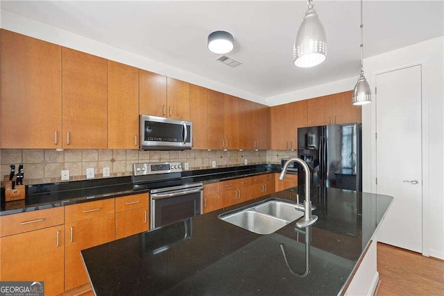 711 Cosmopolitan Dr NE Unit 300, Atlanta, GA 30324 - kitchen with appliances with stainless steel finishes, a sink, backsplash, and brown cabinetry
