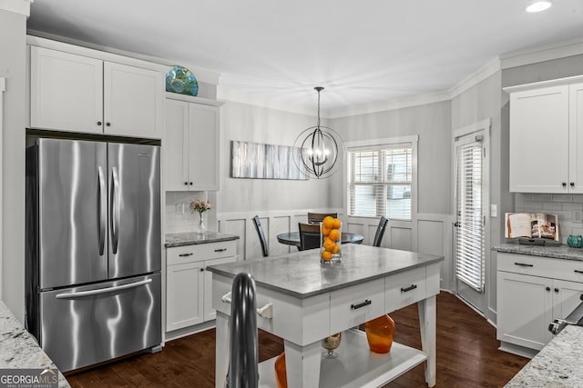 1111 Cobblestone Dr, Bogart, GA 30622 - kitchen featuring freestanding refrigerator, a chandelier, white cabinets, dark wood-style floors, and a wainscoted wall