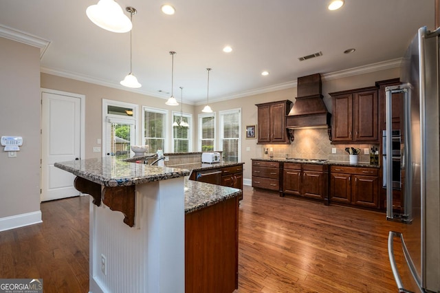 13042 Dartmore Ave, Alpharetta, GA 30005 - kitchen featuring custom exhaust hood, appliances with stainless steel finishes, decorative backsplash, dark wood finished floors, and a large island with sink