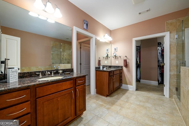 13042 Dartmore Ave, Alpharetta, GA 30005 - bathroom with a stall shower, two vanities, a spacious closet, and baseboards