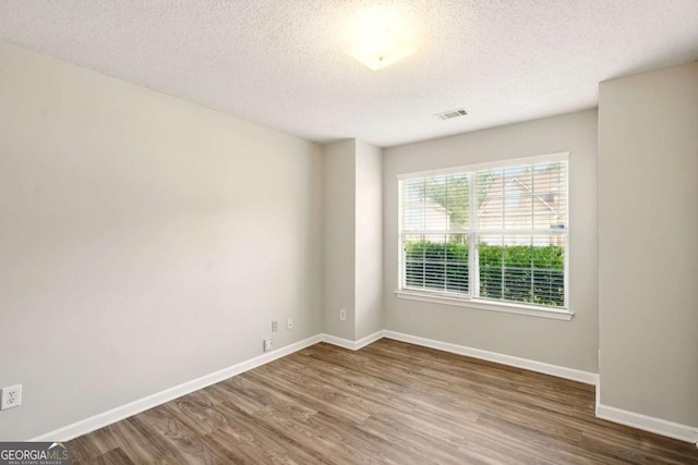 3731 Laramie Rd, Ellenwood, GA 30294 - empty room with wood finished floors, a textured ceiling, and baseboards