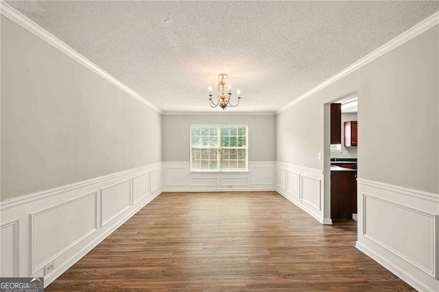 3731 Laramie Rd, Ellenwood, GA 30294 - unfurnished dining area featuring a chandelier, a textured ceiling, dark wood-type flooring, crown molding, and a decorative wall