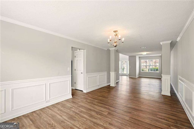 3731 Laramie Rd, Ellenwood, GA 30294 - spare room with a chandelier, a textured ceiling, ornamental molding, dark wood-type flooring, and a decorative wall
