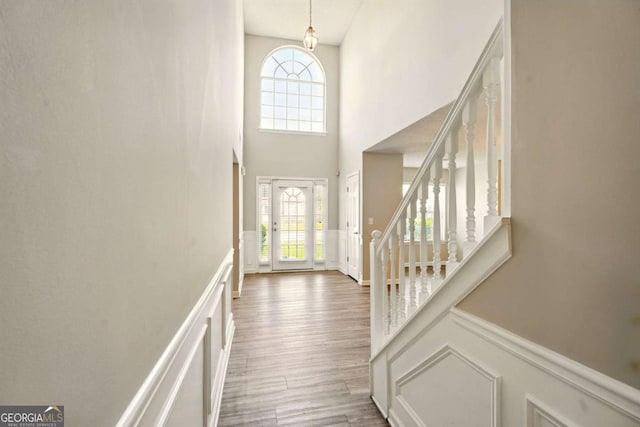 3731 Laramie Rd, Ellenwood, GA 30294 - foyer entrance with stairs, a wainscoted wall, a towering ceiling, a decorative wall, and wood finished floors