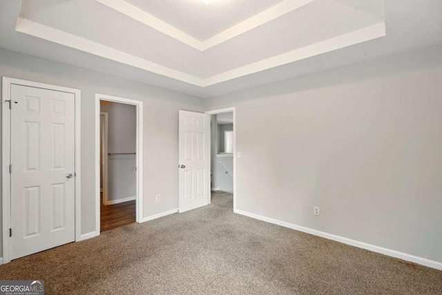 3731 Laramie Rd, Ellenwood, GA 30294 - unfurnished bedroom with a raised ceiling, carpet floors, baseboards, and a walk in closet