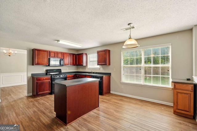 3731 Laramie Rd, Ellenwood, GA 30294 - kitchen featuring black appliances, dark countertops, a textured ceiling, reddish brown cabinets, and light wood-style floors