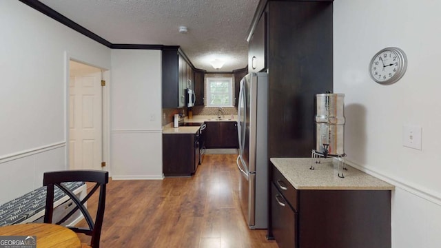 2060 Simonton Bridge Rd, Watkinsville, GA 30677 - kitchen with stainless steel appliances, light countertops, dark brown cabinetry, dark wood finished floors, and ornamental molding