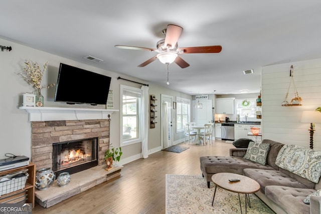 6540 Terracewood Ln, Gainesville, GA 30506 - living room featuring a ceiling fan, light wood-style floors, a fireplace, and baseboards