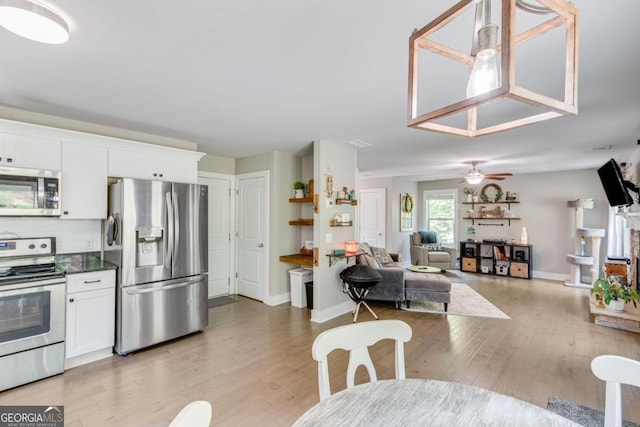 6540 Terracewood Ln, Gainesville, GA 30506 - kitchen with stainless steel appliances, white cabinets, light wood-style floors, and baseboards