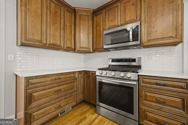 85 Bloomfield Way, Sharpsburg, GA 30277 - kitchen featuring stainless steel appliances, tasteful backsplash, light countertops, and brown cabinets