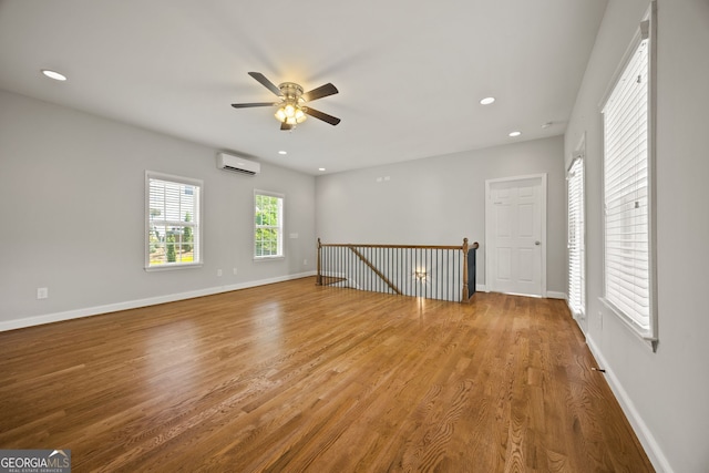 85 Bloomfield Way, Sharpsburg, GA 30277 - unfurnished room featuring a wall unit AC, ceiling fan, wood finished floors, baseboards, and recessed lighting