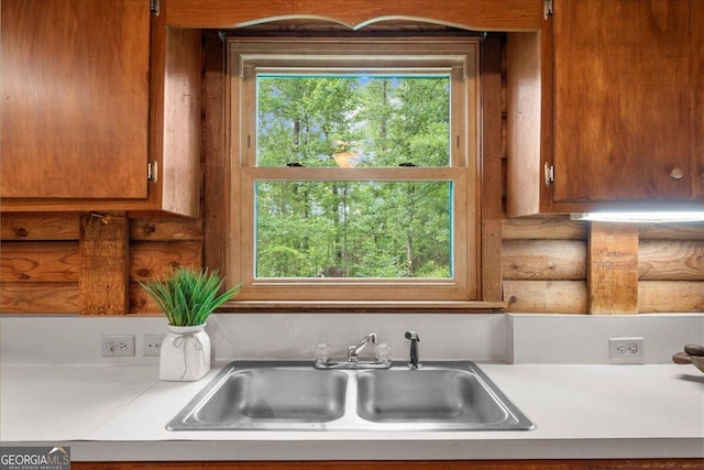 15 Bailey St, Whitesburg, GA 30185 - kitchen featuring a sink, light countertops, and brown cabinetry