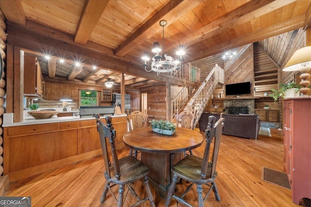 15 Bailey St, Whitesburg, GA 30185 - dining area with light wood-style floors, wood ceiling with exposed beams, a fireplace, a chandelier, and stairway