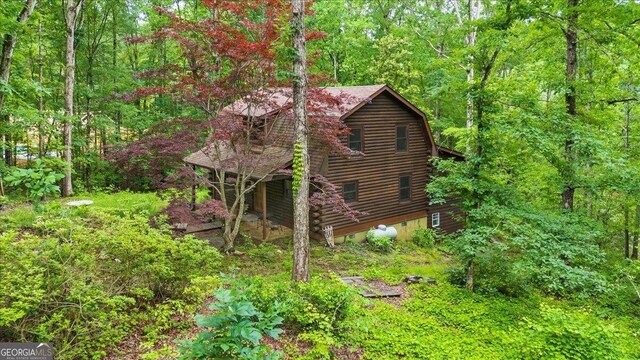 15 Bailey St, Whitesburg, GA 30185 - view of side of home with log exterior, a wooded view, and a gambrel roof