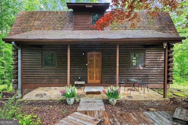 15 Bailey St, Whitesburg, GA 30185 - cabin featuring covered porch, log siding, and roof with shingles
