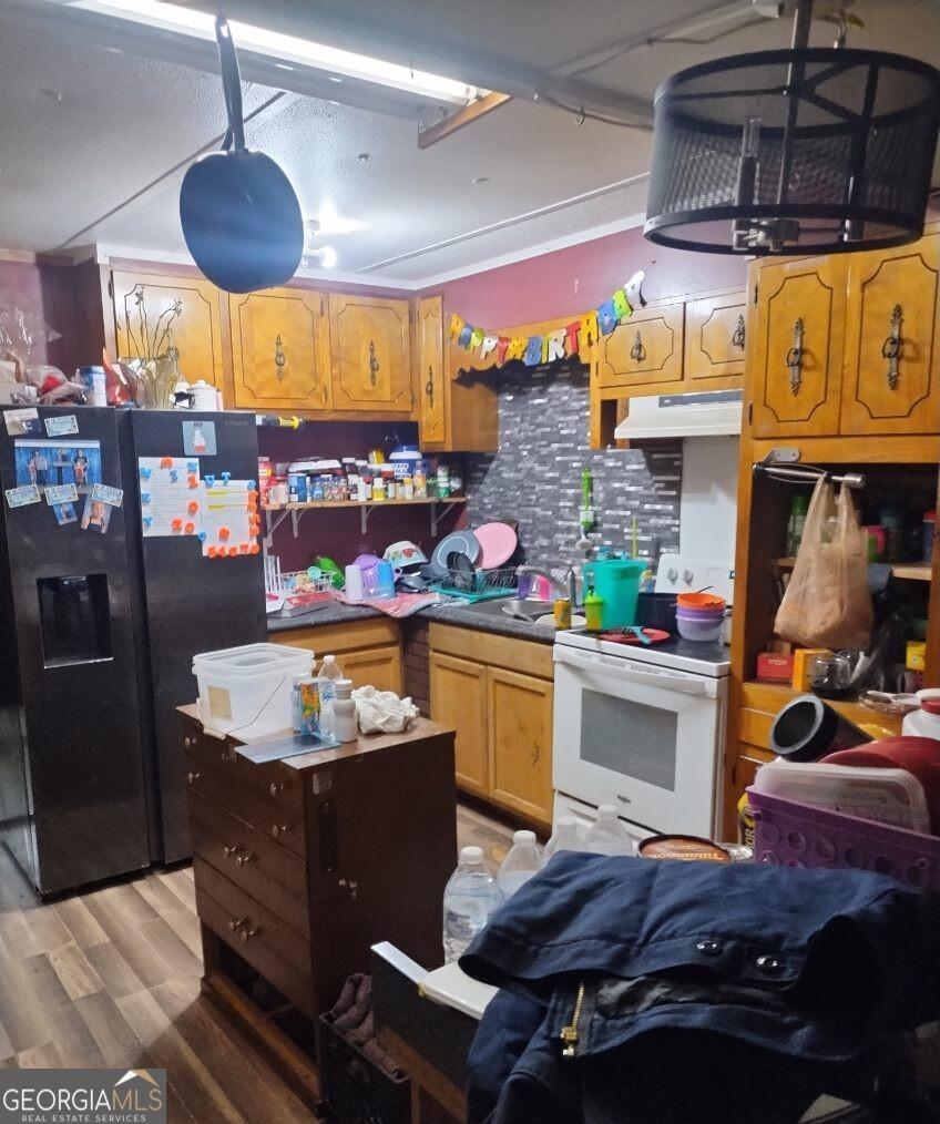231 Pine Dr, Waycross, GA 31503 - kitchen featuring refrigerator with ice dispenser, white electric range, under cabinet range hood, light wood-style floors, and backsplash