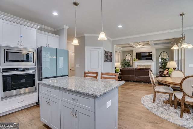895 Lillian Park Dr, Grovetown, GA 30813 - kitchen with appliances with stainless steel finishes, crown molding, light wood finished floors, decorative light fixtures, and a kitchen island