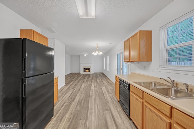 7459 Old Chapel, South Fulton, GA 30349 - kitchen with black appliances, light wood-style floors, a textured ceiling, light countertops, and a lit fireplace