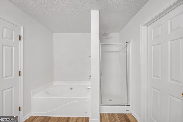 7459 Old Chapel, South Fulton, GA 30349 - bathroom with wood finished floors, a stall shower, a bath, and a textured ceiling