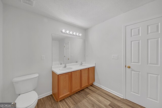 7459 Old Chapel, South Fulton, GA 30349 - bathroom featuring a textured ceiling, wood finished floors, and double vanity