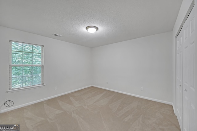 7459 Old Chapel, South Fulton, GA 30349 - unfurnished bedroom with a closet, light colored carpet, and a textured ceiling