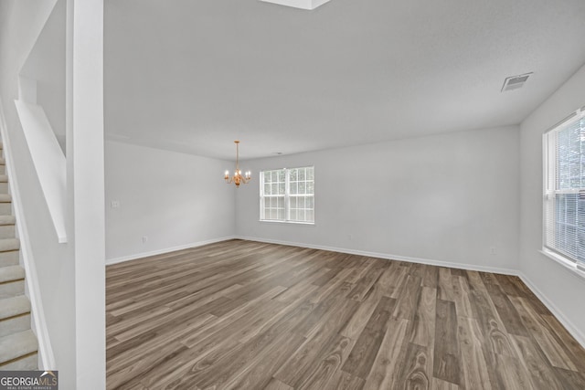 7459 Old Chapel, South Fulton, GA 30349 - spare room featuring stairway, wood finished floors, a chandelier, and healthy amount of natural light