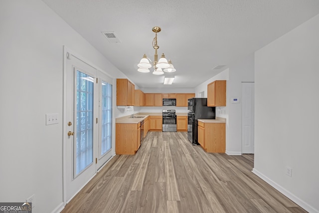 7459 Old Chapel, South Fulton, GA 30349 - kitchen featuring black appliances, light countertops, a chandelier, light wood-type flooring, and pendant lighting