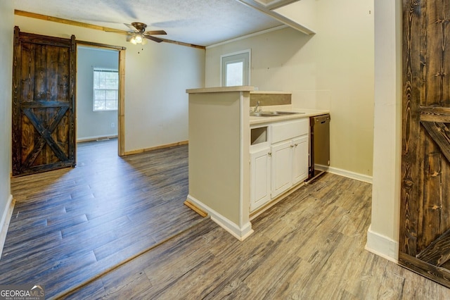 6 Mill St, Jackson, GA 30233 - kitchen featuring a barn door, a ceiling fan, dishwasher, baseboards, and crown molding
