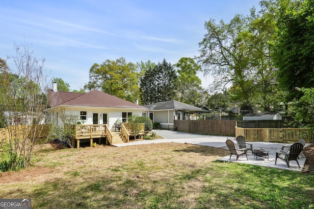 102 Rockyford Rd, Atlanta, GA 30317 - back of property with a wooden deck, an outdoor fire pit, a patio, and a chimney