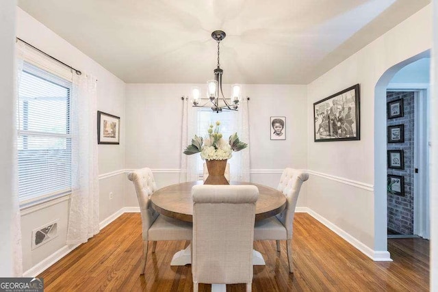 913 7th Ave, Albany, GA 31701 - dining space featuring arched walkways, a chandelier, and wood finished floors