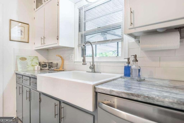 913 7th Ave, Albany, GA 31701 - kitchen featuring dishwasher, backsplash, light countertops, and white cabinets