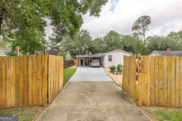 913 7th Ave, Albany, GA 31701 - view of front facade with concrete driveway, a carport, and a gate