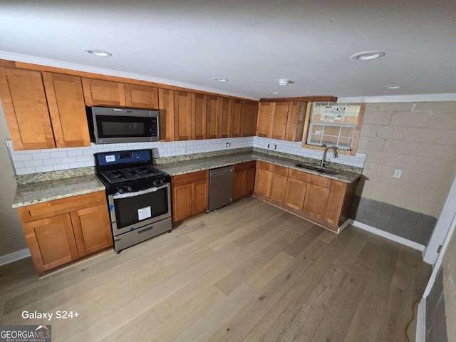 2812 Maple Rd SE, Rome, GA 30161 - kitchen featuring stainless steel appliances, a sink, brown cabinets, light stone counters, and light wood finished floors