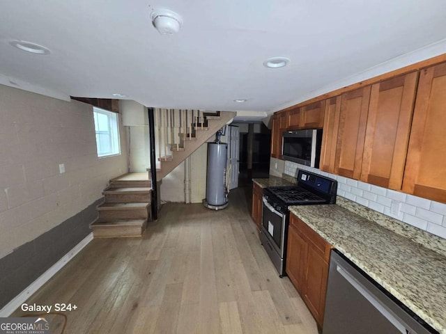 2812 Maple Rd SE, Rome, GA 30161 - kitchen with stainless steel appliances, water heater, brown cabinets, and light wood-type flooring