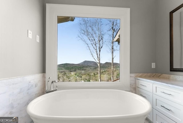 146 David Dr, Tiger, GA 30576 - bathroom featuring a freestanding tub, healthy amount of natural light, vanity, a mountain view, and tile walls