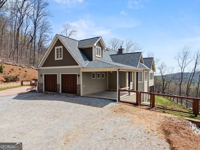 146 David Dr, Tiger, GA 30576 - view of front of property featuring a chimney, a garage, stone siding, gravel driveway, and roof with shingles