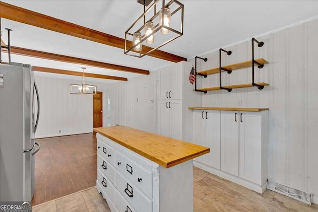 612 Oakcrest Dr, Rockmart, GA 30153 - kitchen with freestanding refrigerator, a chandelier, butcher block countertops, white cabinetry, and beamed ceiling