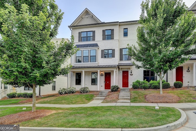 3360 Pickens St, Duluth, GA 30096 - townhome / multi-family property with brick siding, a standing seam roof, and a front lawn