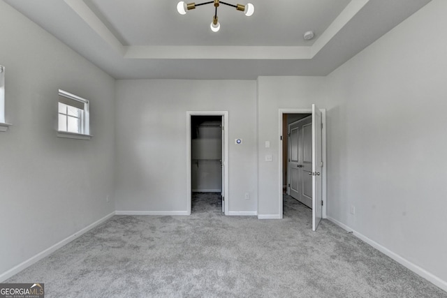 3360 Pickens St, Duluth, GA 30096 - unfurnished bedroom featuring a raised ceiling, a walk in closet, carpet floors, and baseboards