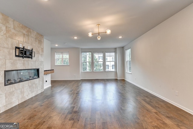 3360 Pickens St, Duluth, GA 30096 - unfurnished living room featuring a fireplace, dark wood-style flooring, baseboards, recessed lighting, and a chandelier