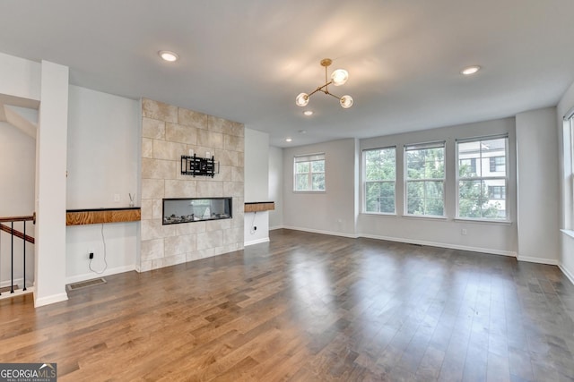 3360 Pickens St, Duluth, GA 30096 - unfurnished living room with a tiled fireplace, dark wood finished floors, baseboards, recessed lighting, and a chandelier