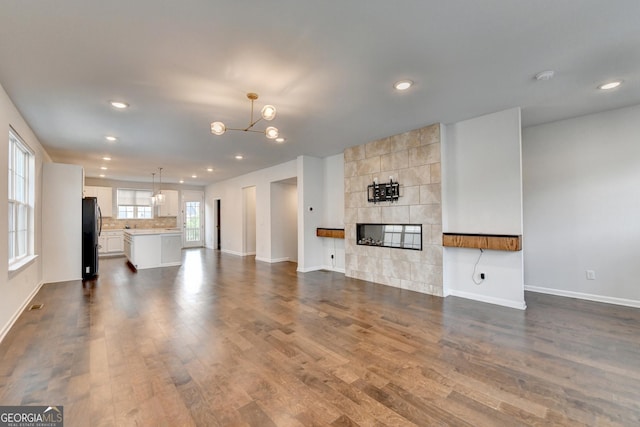 3360 Pickens St, Duluth, GA 30096 - unfurnished living room featuring baseboards, dark wood-style floors, a chandelier, a tiled fireplace, and recessed lighting