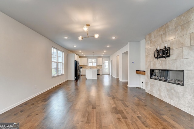 3360 Pickens St, Duluth, GA 30096 - unfurnished living room with baseboards, dark wood-type flooring, a fireplace, recessed lighting, and a chandelier