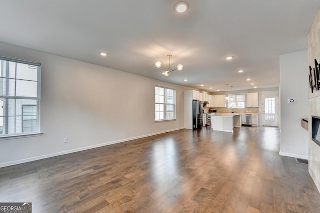 3360 Pickens St, Duluth, GA 30096 - unfurnished living room featuring recessed lighting, dark wood finished floors, baseboards, and a chandelier