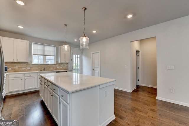 3360 Pickens St, Duluth, GA 30096 - kitchen with dark wood finished floors, white cabinetry, a sink, a kitchen island, and backsplash